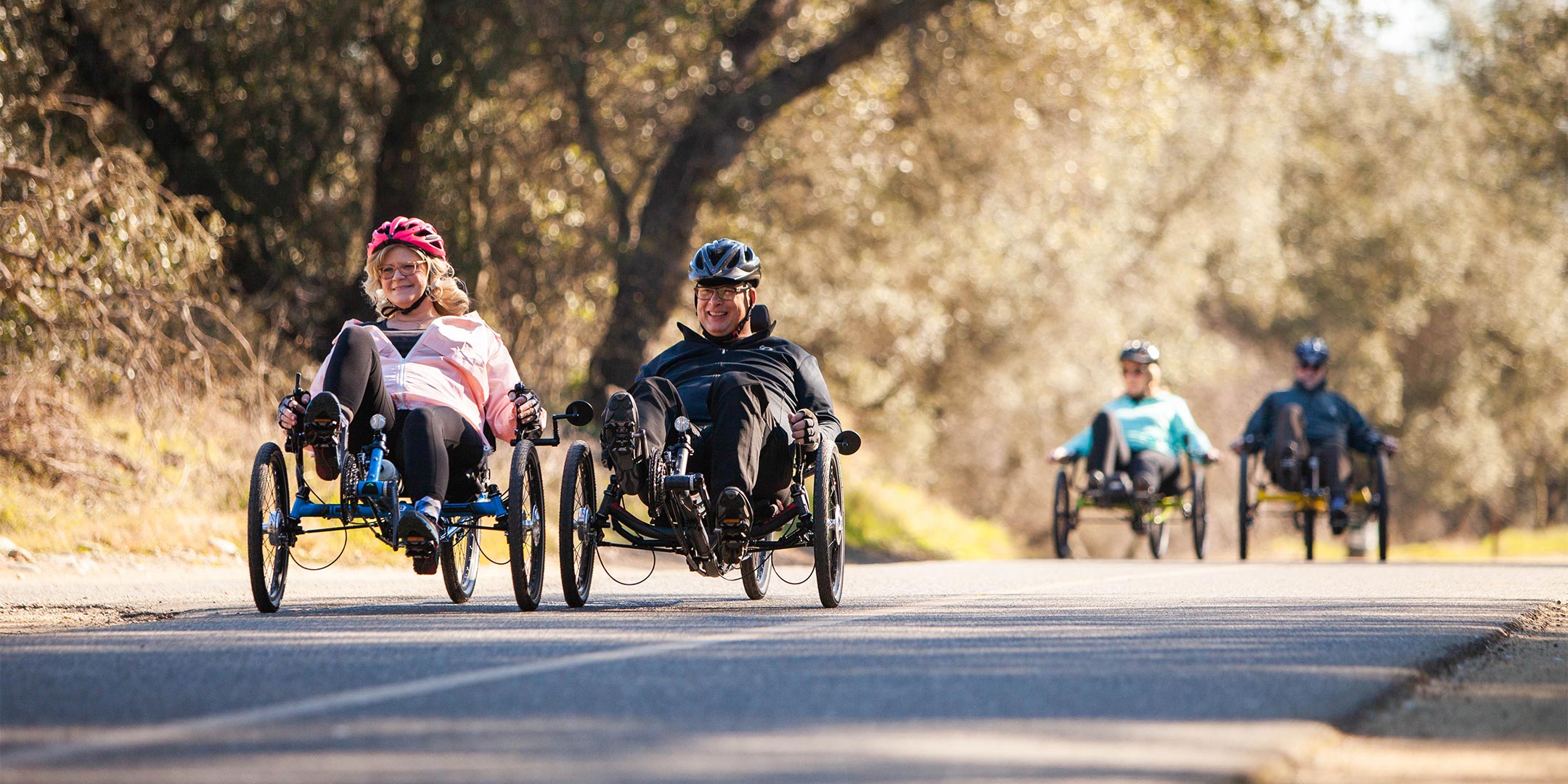 younger and older couple riding recumbent trikes on the American River Bike Trail