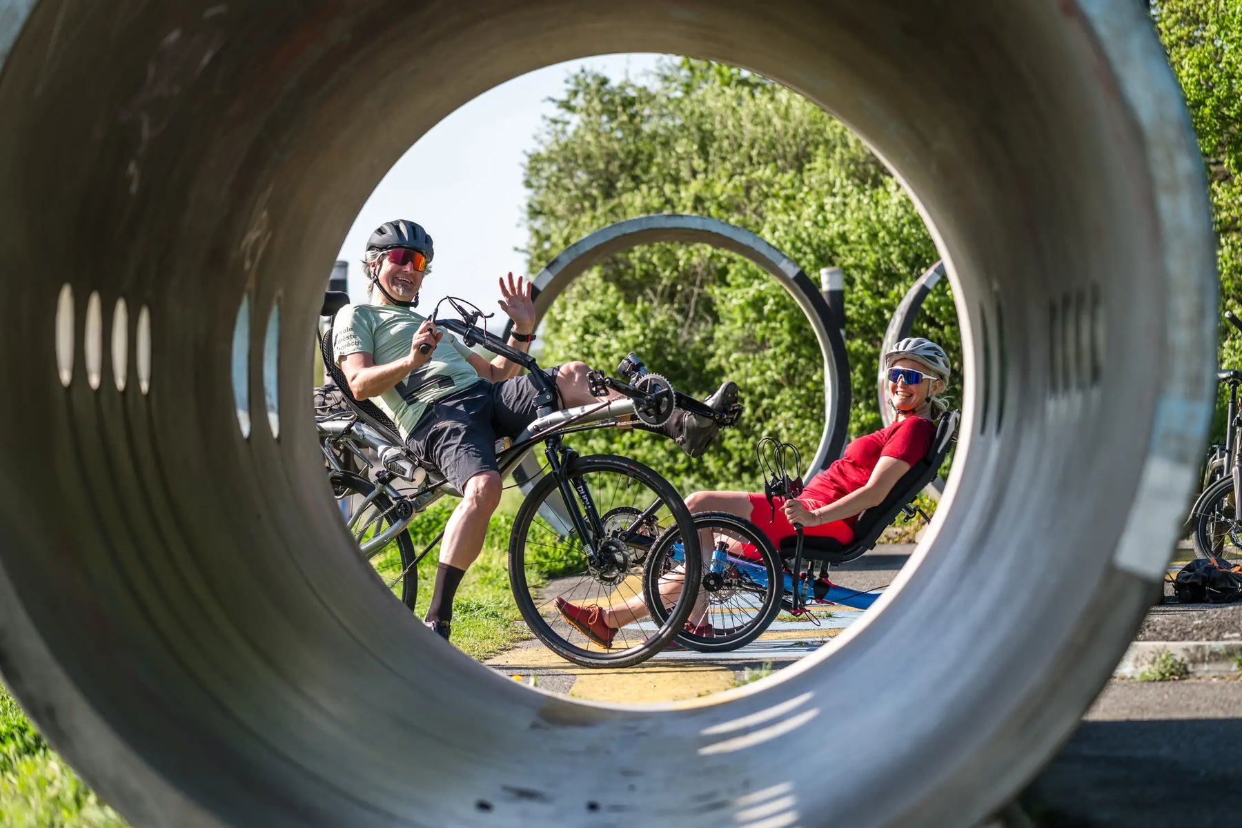 Two riders relaxing on AZUB TRIcon 20 recumbent trikes on a sunny day