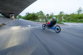 Rider on a blue AZUB TRIcon 20 recumbent trike cruising a paved cycle path