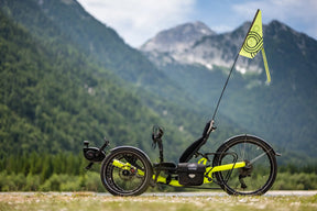 AZUB Ti-FLY 26 recumbent trike side profile on a mountain path with a safety flag