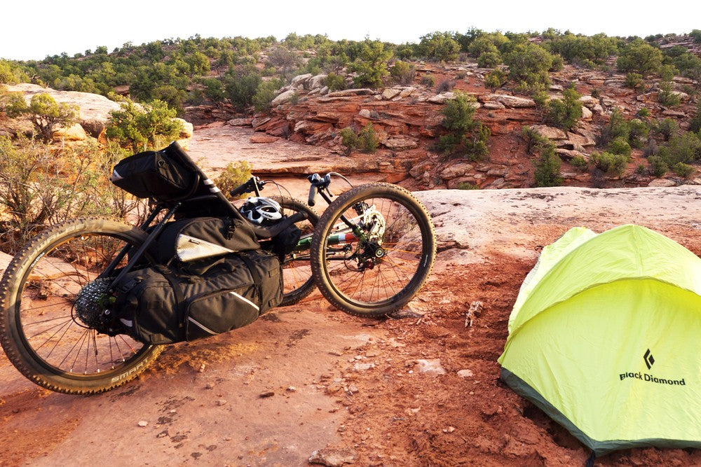 TerraTrike All Terrain recumbent trike loaded with bikepacking gear at a desert camp on red rock