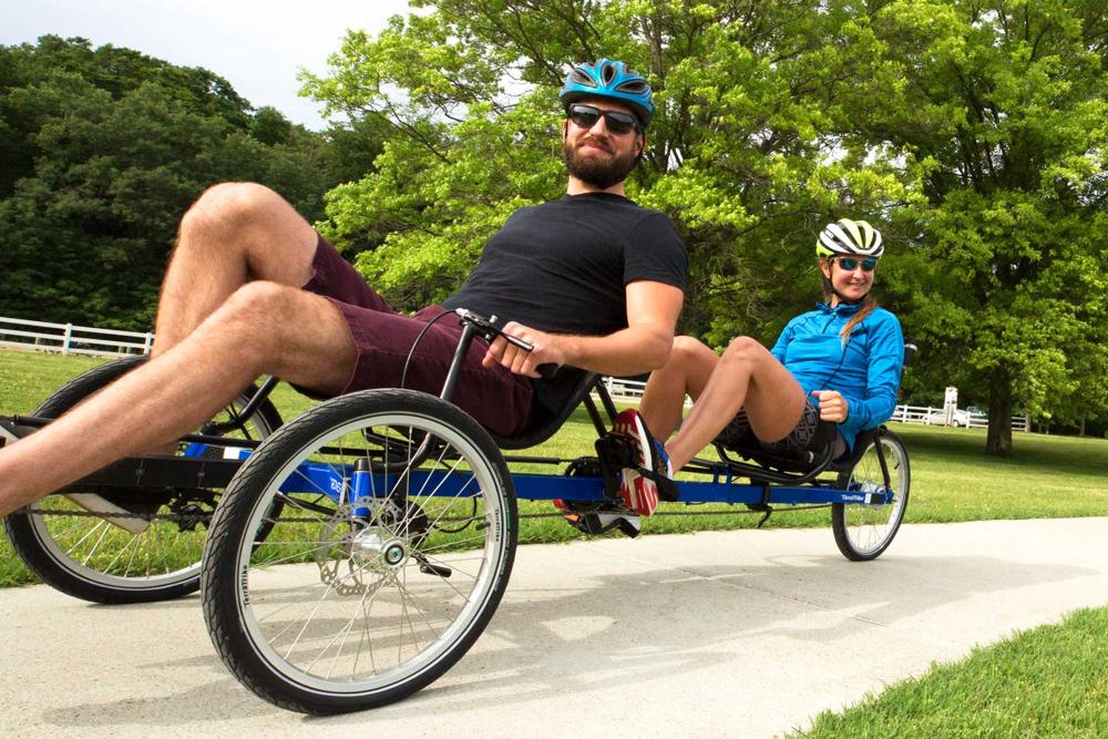 Riders on a TerraTrike Rover Tandem recumbent tandem trike on a grass path