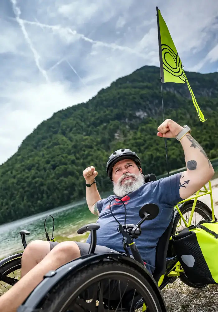 Rider on an AZUB TRIcon GR recumbent trike beside a mountain lake