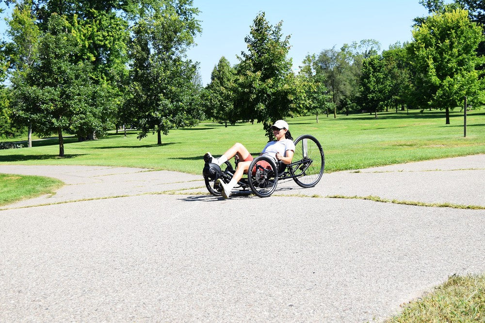 Rider on a TerraTrike Spyder e+ electric recumbent trike on a park path